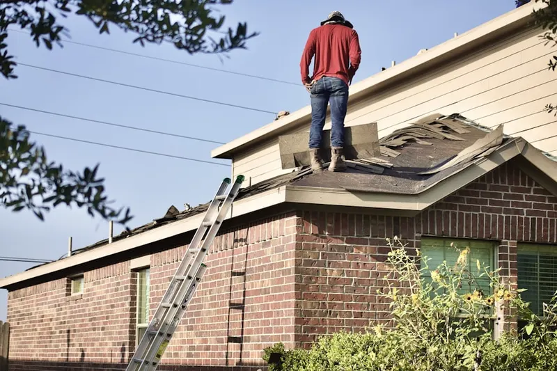 Professional roofer working on a residential roof in Ludlow Falls